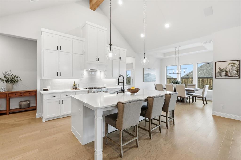 11116 Emory Oak Ridge Flower Mound, TX 76226 - Photo 11 of 40 a kitchen with white cabinets and chairs
