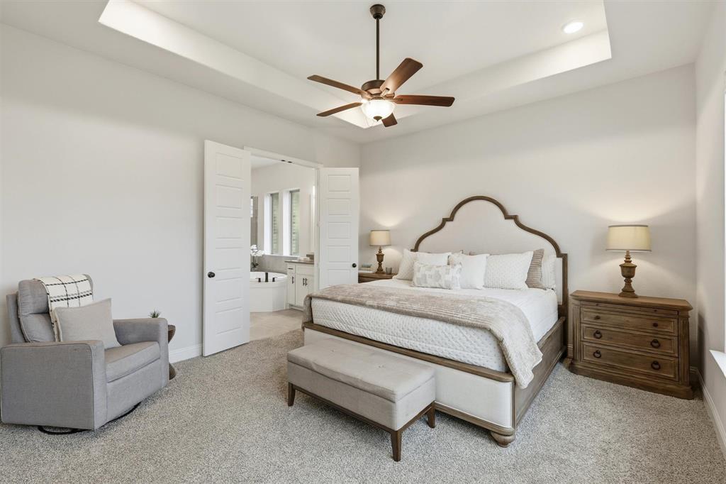 11116 Emory Oak Ridge Flower Mound, TX 76226 - Photo 15 of 40 a bedroom with a bed a couch and a chandelier
