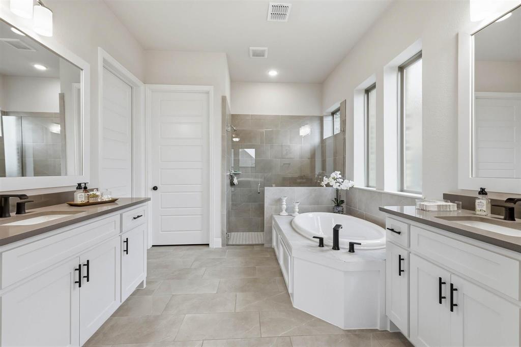 11116 Emory Oak Ridge Flower Mound, TX 76226 - Photo 17 of 40 a large white bathroom with a large tub sink and mirror
