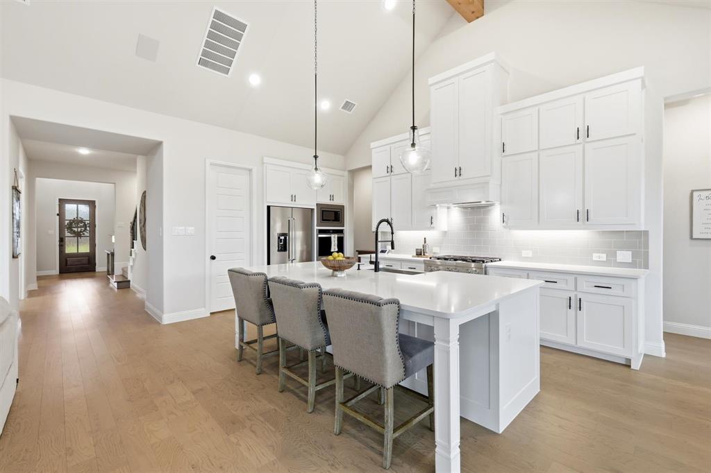11116 Emory Oak Ridge Flower Mound, TX 76226 - Photo 10 of 40 a kitchen with kitchen island granite countertop a sink a center island and stainless steel appliances
