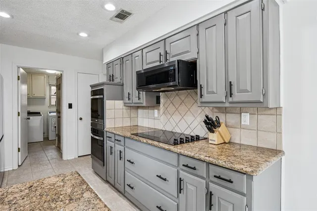 a kitchen with stainless steel appliances granite countertop a refrigerator stove and microwave