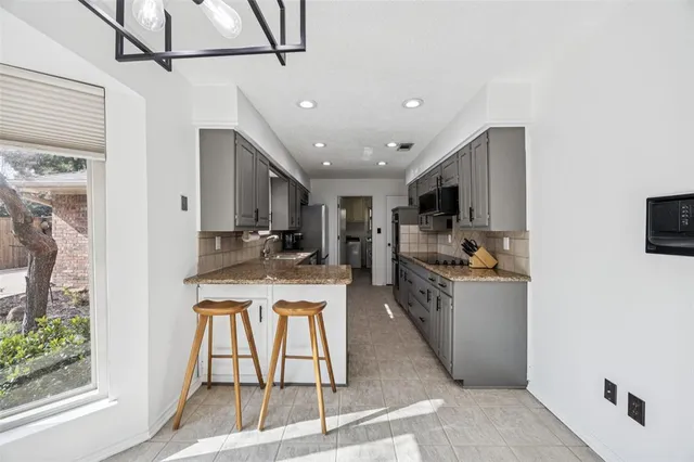 a kitchen with stainless steel appliances kitchen island granite countertop a stove and a refrigerator