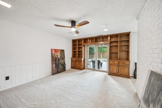 a view of an empty room with a fireplace and a window