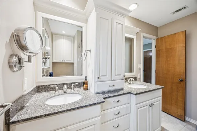 a bathroom with a granite countertop double vanity sinks and a mirror