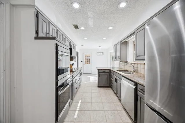 a kitchen with stainless steel appliances granite countertop a refrigerator and a sink