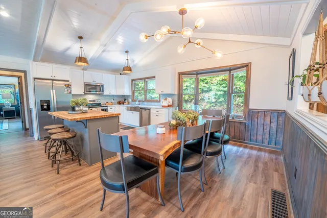 a dining room with stainless steel appliances granite countertop a stove and a refrigerator