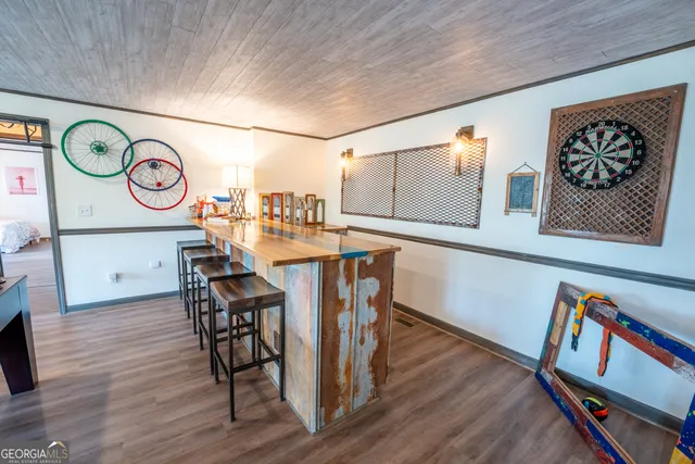 a living room with furniture pool table and a wooden floor