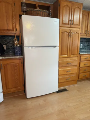 a view of a kitchen with refrigerator and cabinet