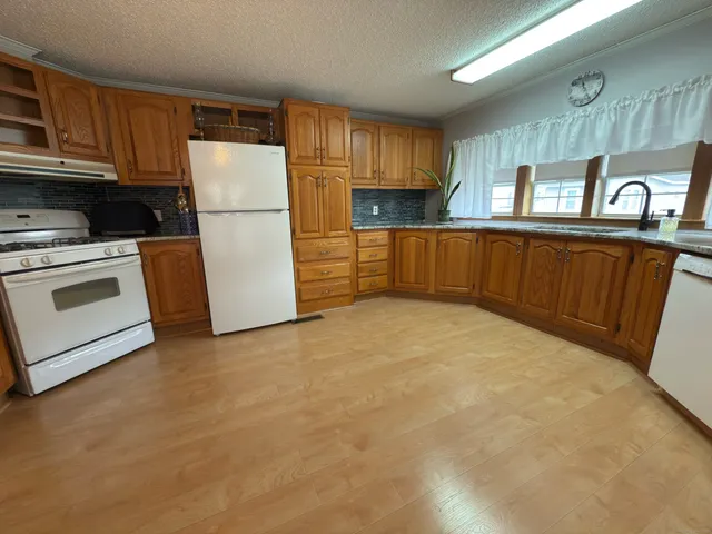 a kitchen with refrigerator cabinets and wooden floor