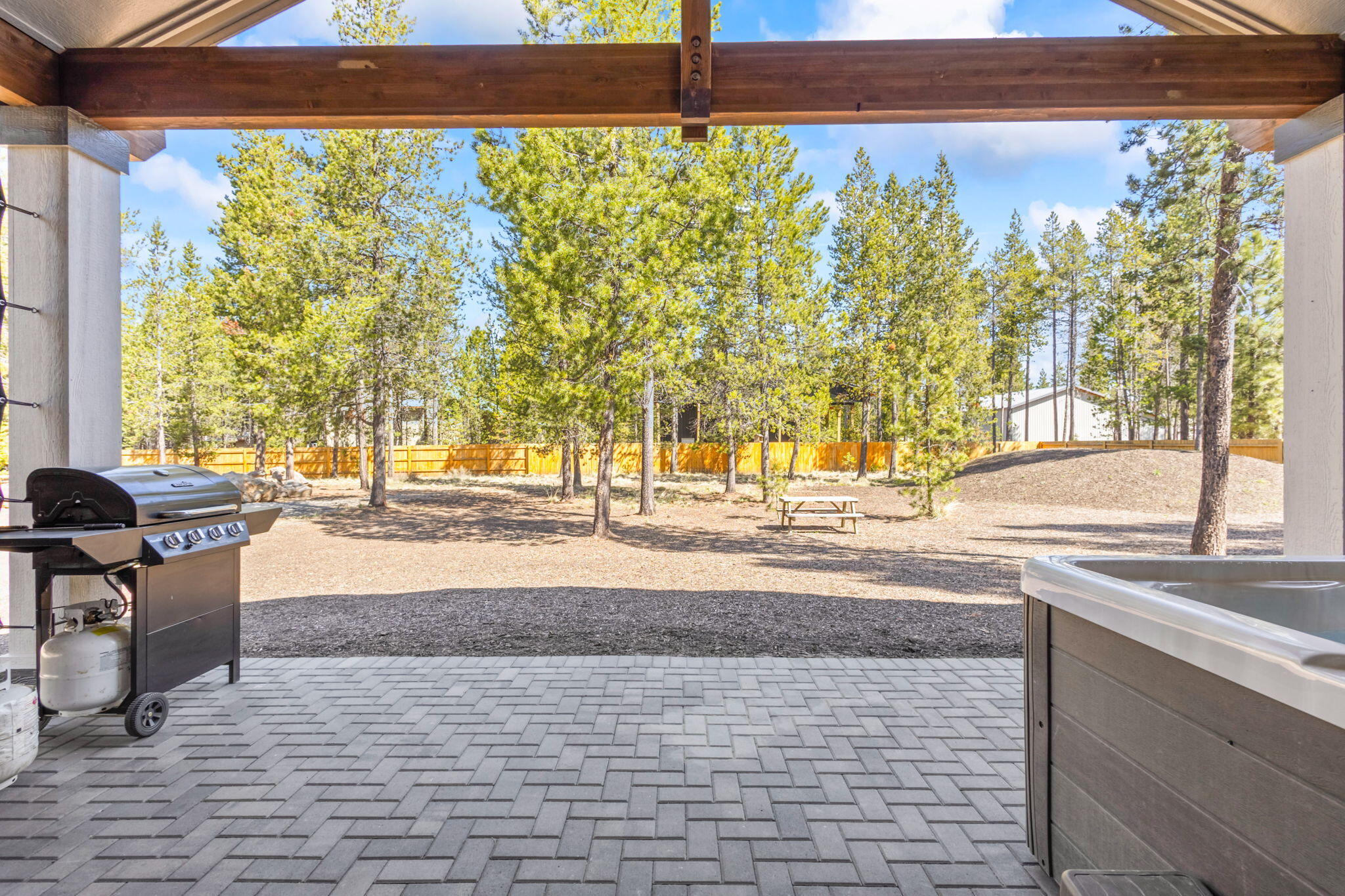 17138 Downey Road Bend, OR 97707 - Photo 35 of 57 Large back patio with vaulted ceiling and exposed wood beams.