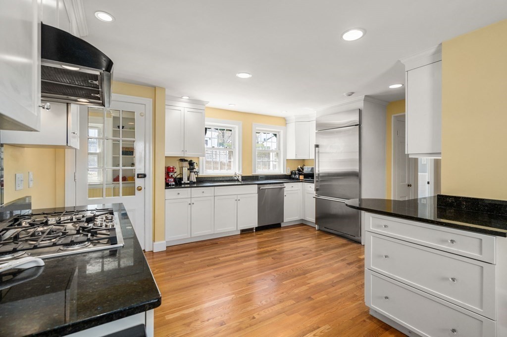 144 Reservoir Road Brookline, MA 02467 - Photo 20 of 21 a kitchen with stainless steel appliances kitchen island granite countertop a stove a sink and a refrigerator