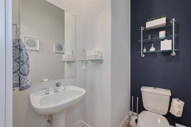 a bathroom with a sink toilet and mirror