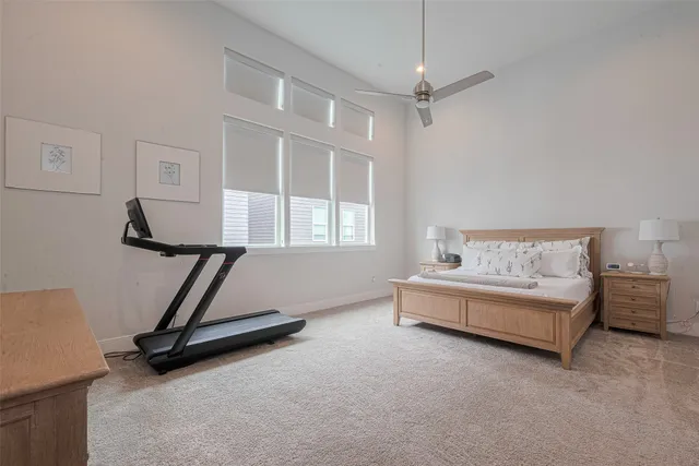 a living room with furniture gym equipment and a ceiling fan