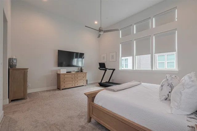 a bedroom with a bed tv and a window