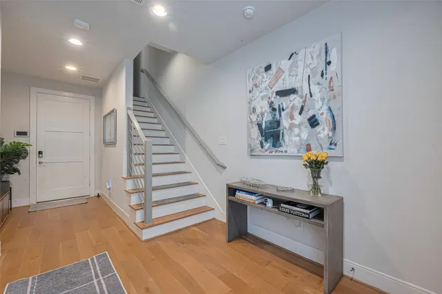 wooden floor with white walls and stairs