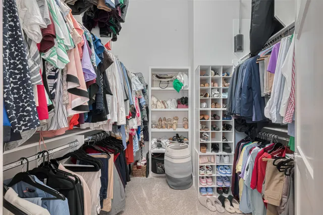 a view of walk in closet with clothes and shoes