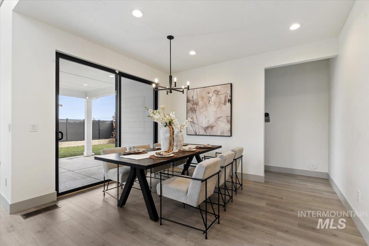 7580 West Old School Street, Unit FREMONT Meridian, ID 83646 - Photo 11 of 28 Dining space featuring light wood-style flooring and hanging lights
