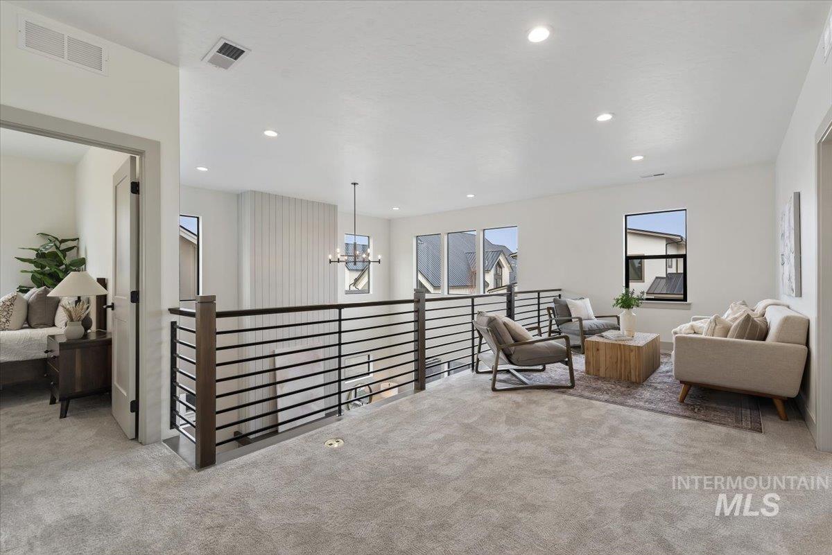 7580 West Old School Street, Unit FREMONT Meridian, ID 83646 - Photo 13 of 28 Living area with an upstairs landing, light colored carpet, and hanging lights