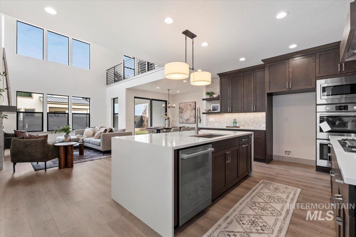 7580 West Old School Street, Unit FREMONT Meridian, ID 83646 - Photo 27 of 28 Kitchen featuring light stone countertops, pendant lighting, open floor plan, open shelves, and light wood finished floors
