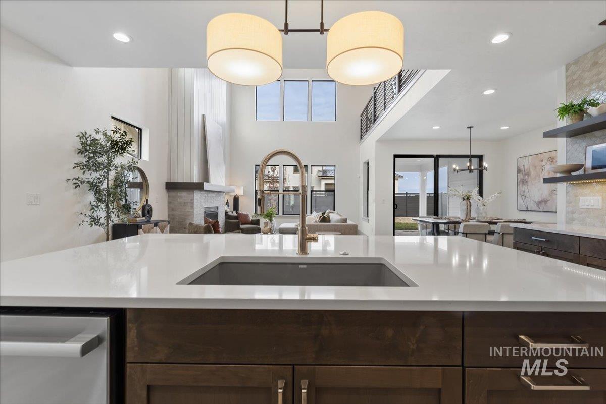 7580 West Old School Street, Unit FREMONT Meridian, ID 83646 - Photo 28 of 28 Kitchen featuring dark wood finish cabinets, open floor plan, open shelves, a fireplace, and a high ceiling