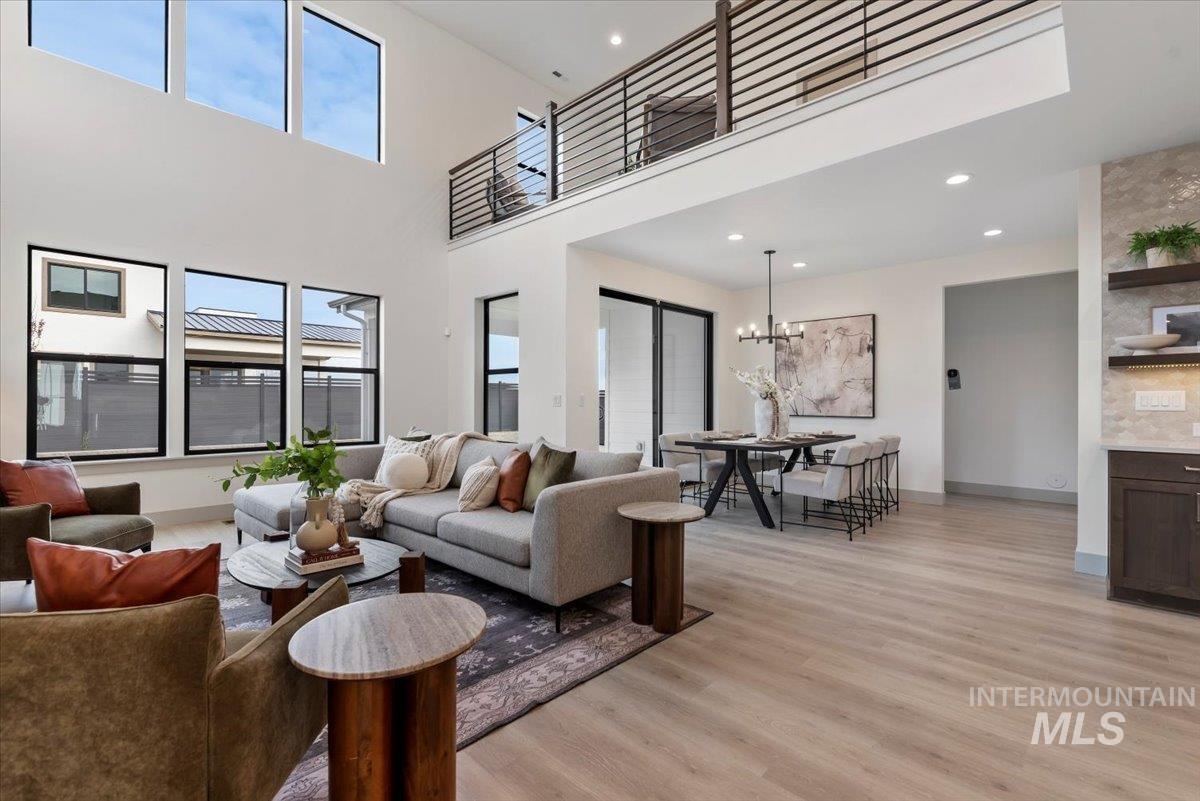 7580 West Old School Street, Unit FREMONT Meridian, ID 83646 - Photo 7 of 28 Living area featuring light wood finished floors, a high ceiling, and hanging lights