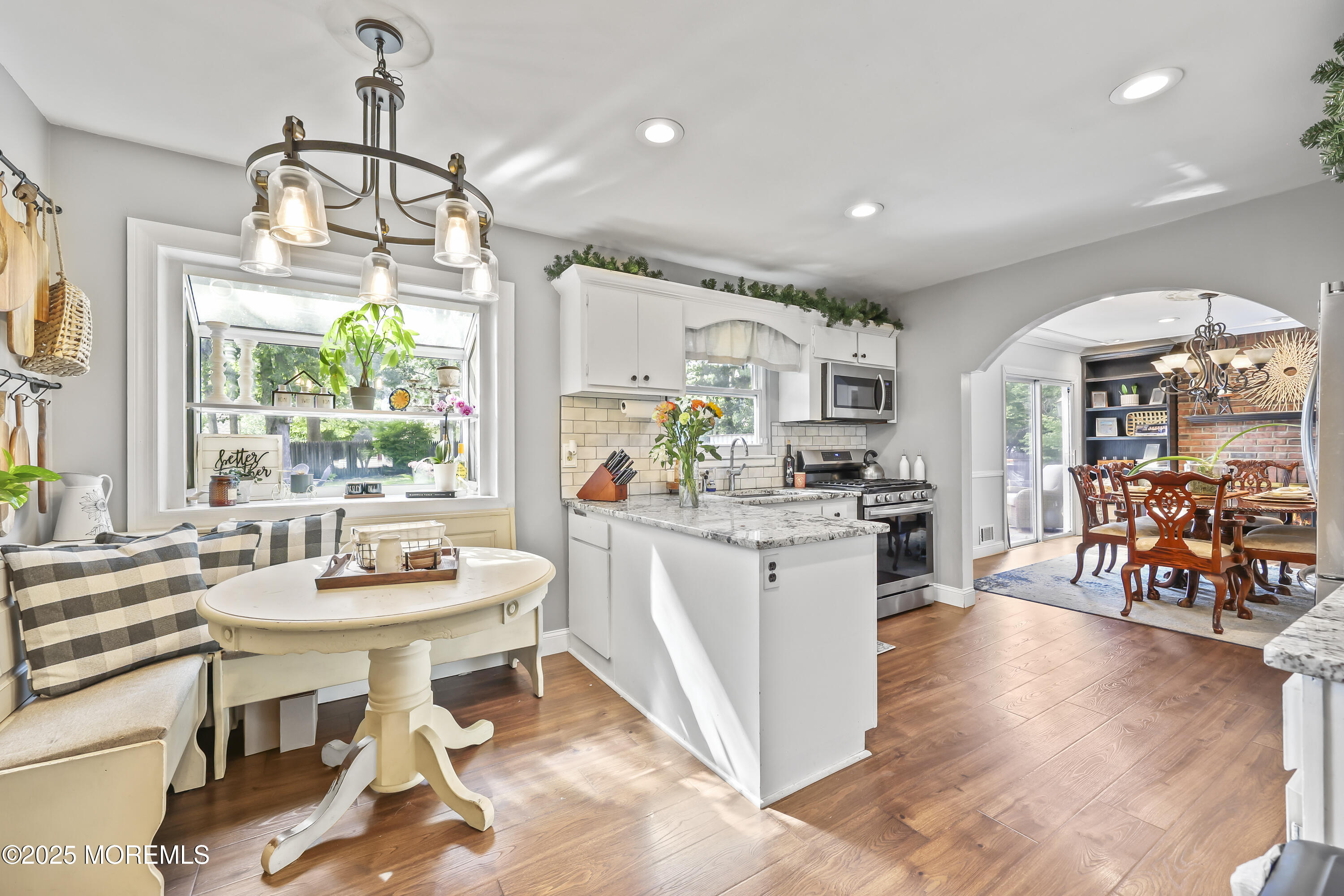91 Newbury Road Howell, NJ 07731 - Photo 16 of 34 a kitchen with stainless steel appliances a dining table chairs stove and white cabinets