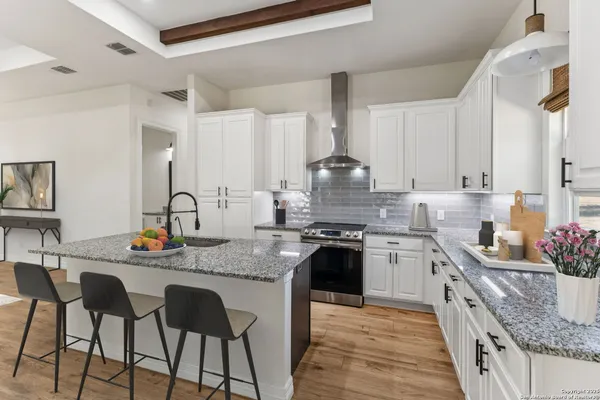 a kitchen with stainless steel appliances granite countertop a sink stove and cabinets