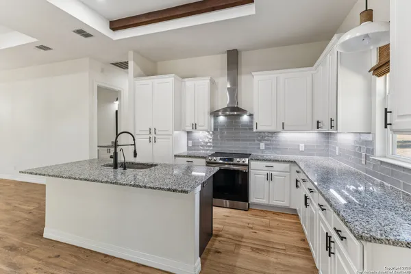 a kitchen with stainless steel appliances granite countertop a sink stove and cabinets