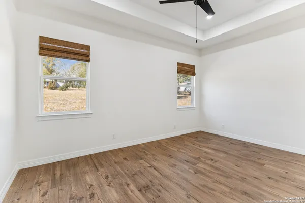 an empty room with a window and a ceiling fan