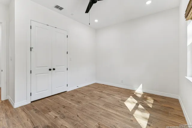 a view of empty room with wooden floor