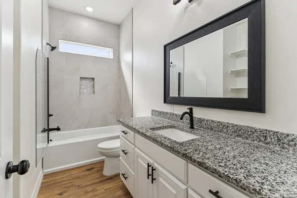 a bathroom with a granite countertop sink toilet and shower