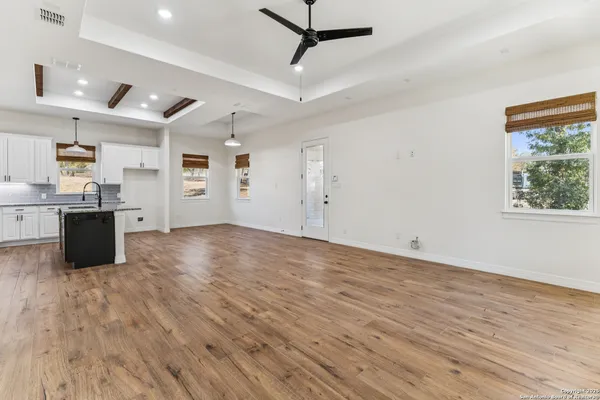 a view of a kitchen with wooden floor and stainless steel appliances
