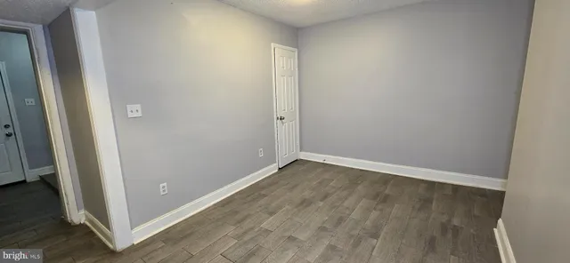 an empty room with wooden floor and entrance