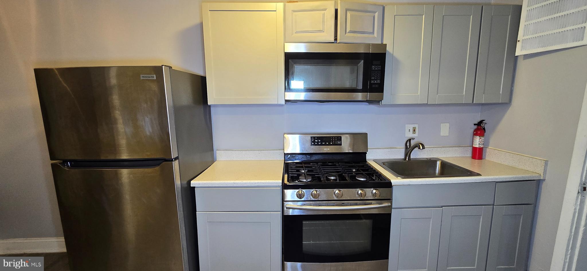 1702 Gales Street Northeast, Unit 3 Washington, DC 20002 - Photo 10 of 13 a kitchen with stainless steel appliances a refrigerator a stove a microwave oven cabinets and a sink