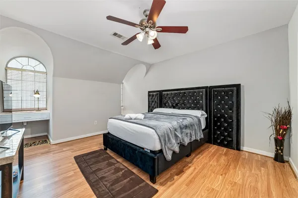 a bedroom with a large bed chandelier and a window