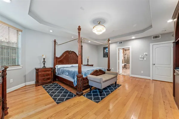 a spacious bedroom with a bed and a dresser