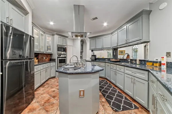 a kitchen with stainless steel appliances kitchen island granite countertop a stove refrigerator and microwave
