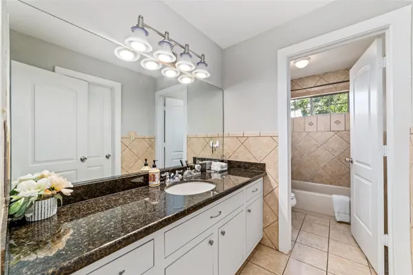 a spacious bathroom with a granite countertop sink a toilet and a shower