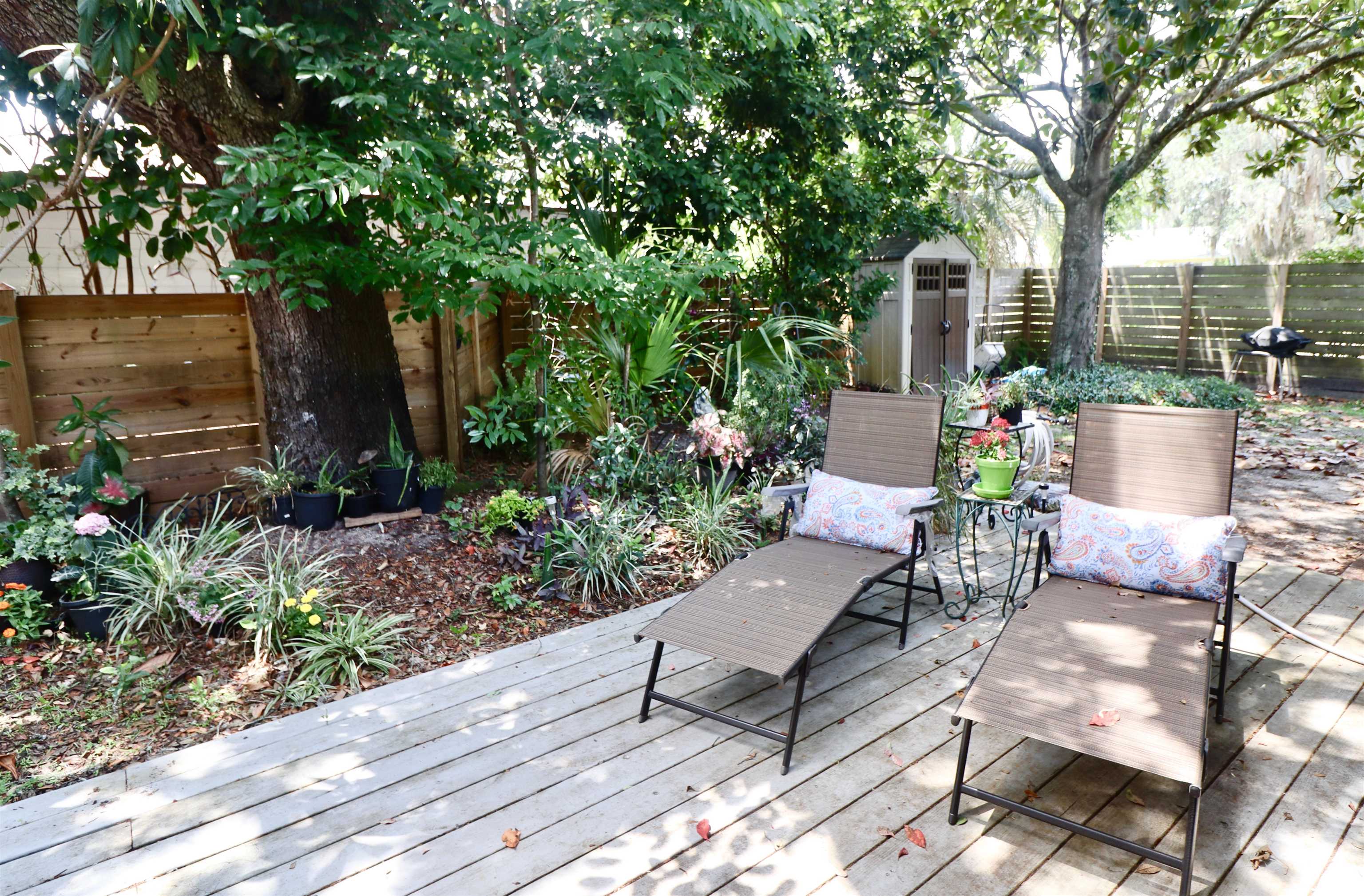 1017 San Remo Road St. Augustine, FL 32086 - Photo 13 of 23 a view of a patio with table and chairs potted plants and large tree
