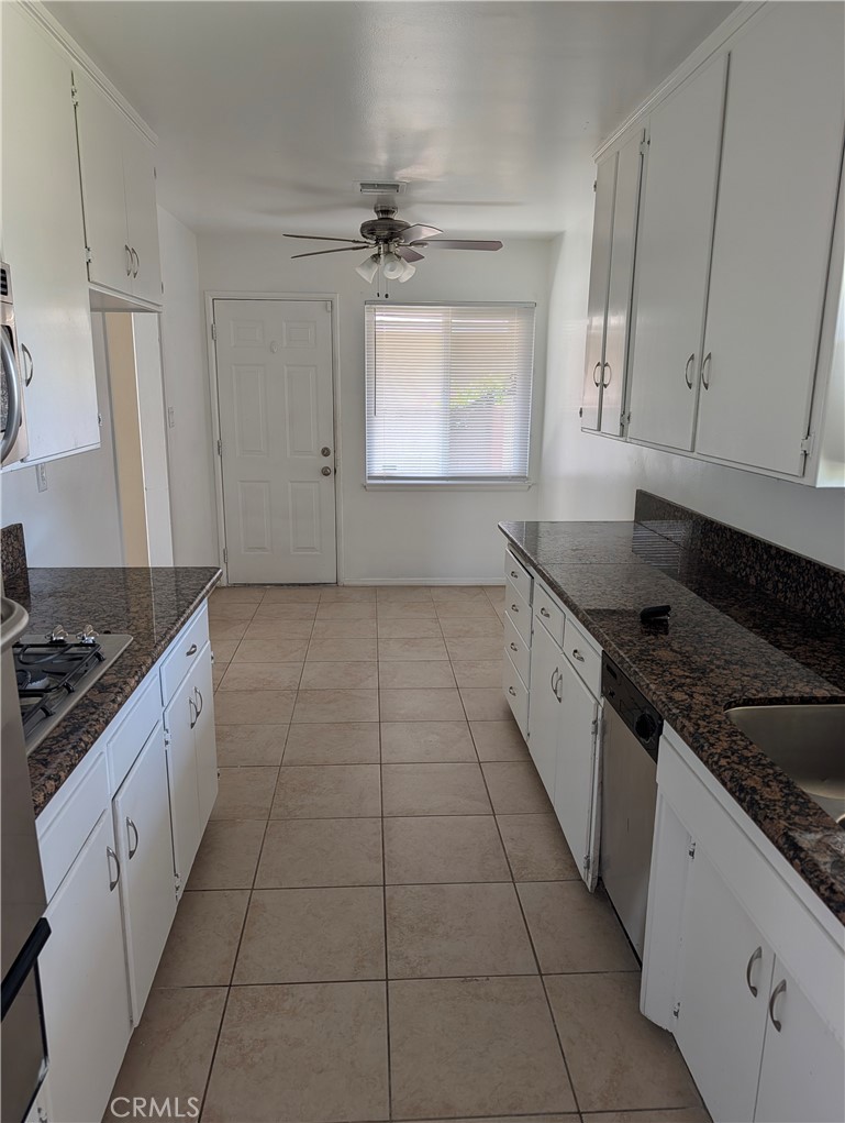 8641 Garfield Street Riverside, CA 92504 - Photo 4 of 19 a kitchen with granite countertop a stove a sink and a refrigerator