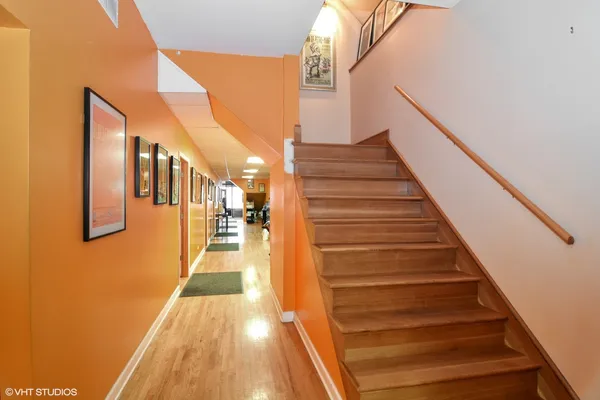 a hallway with a large window and wooden floor