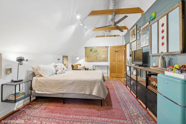 a bedroom with a bed and a flat tv screen on the dresser
