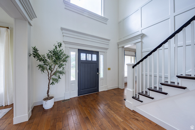 868 Braddock Lane Alpine, UT 84004 - Photo 7 of 64 Entry foyer featuring wood-finish flooring, a dark-paneled door with sidelights, and a grand staircase with dark treads and white risers