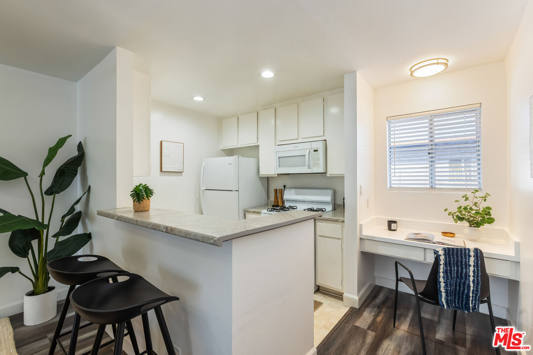 11701 Texas Avenue, Unit 306 Los Angeles, CA 90025 - Photo 20 of 42 a kitchen with stainless steel appliances a table and chairs in it