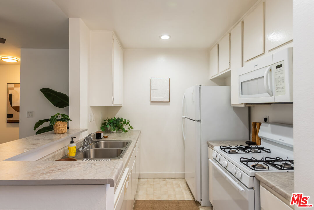 11701 Texas Avenue, Unit 306 Los Angeles, CA 90025 - Photo 22 of 42 a kitchen with white cabinets and appliances