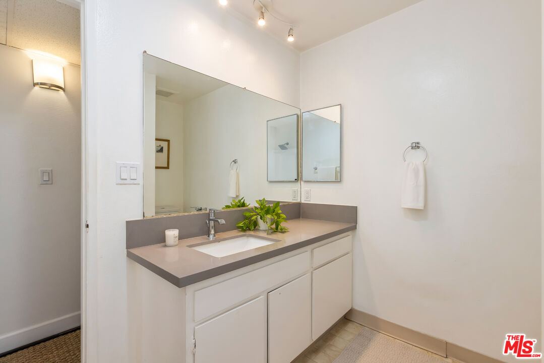 11701 Texas Avenue, Unit 306 Los Angeles, CA 90025 - Photo 38 of 42 a bathroom with a granite countertop sink and a mirror