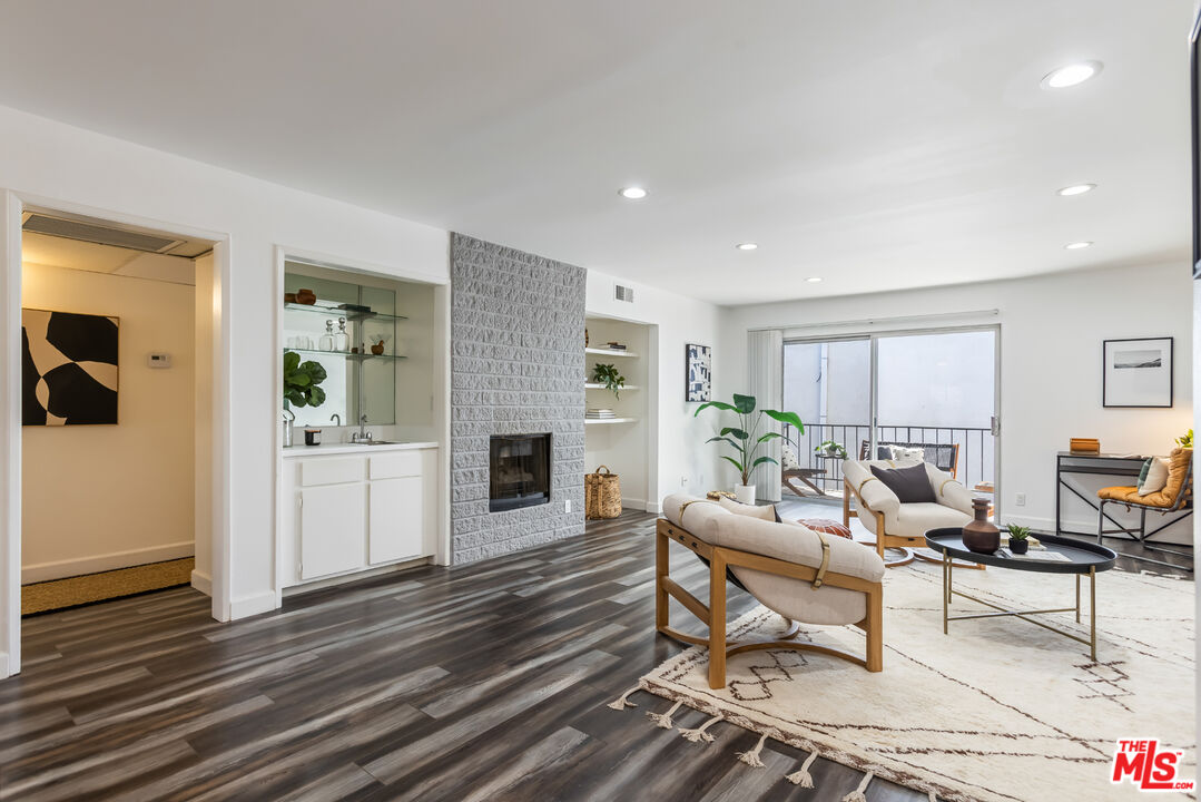 11701 Texas Avenue, Unit 306 Los Angeles, CA 90025 - Photo 4 of 42 a living room with furniture a fireplace and a table