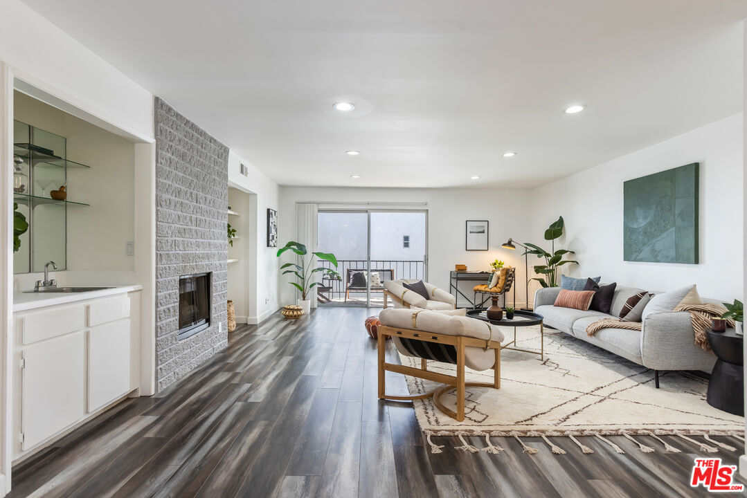 11701 Texas Avenue, Unit 306 Los Angeles, CA 90025 - Photo 5 of 42 a living room with fireplace furniture and a wooden floor