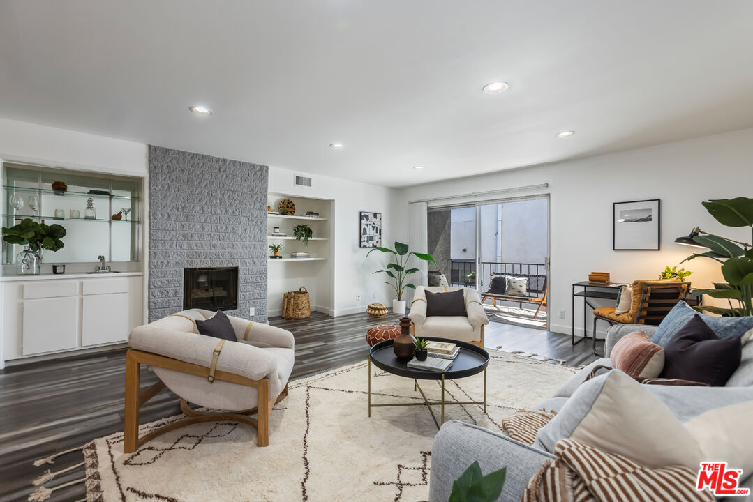 11701 Texas Avenue, Unit 306 Los Angeles, CA 90025 - Photo 8 of 42 a living room with furniture a fireplace a lamp and a window