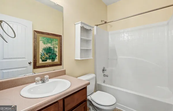 a view of a livingroom with wooden floor and ceiling fan